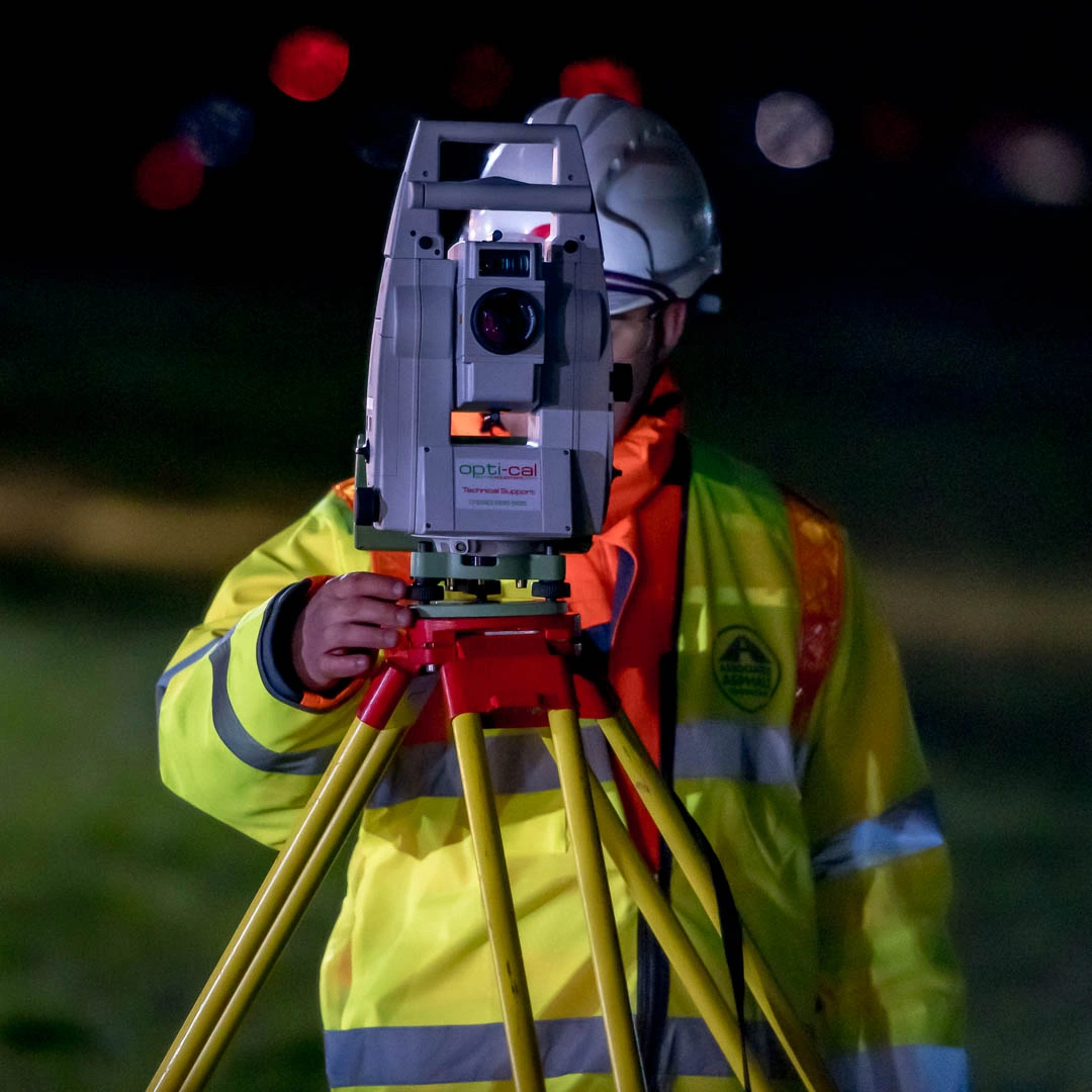 AA Worker using theodolite light to measure angles of road